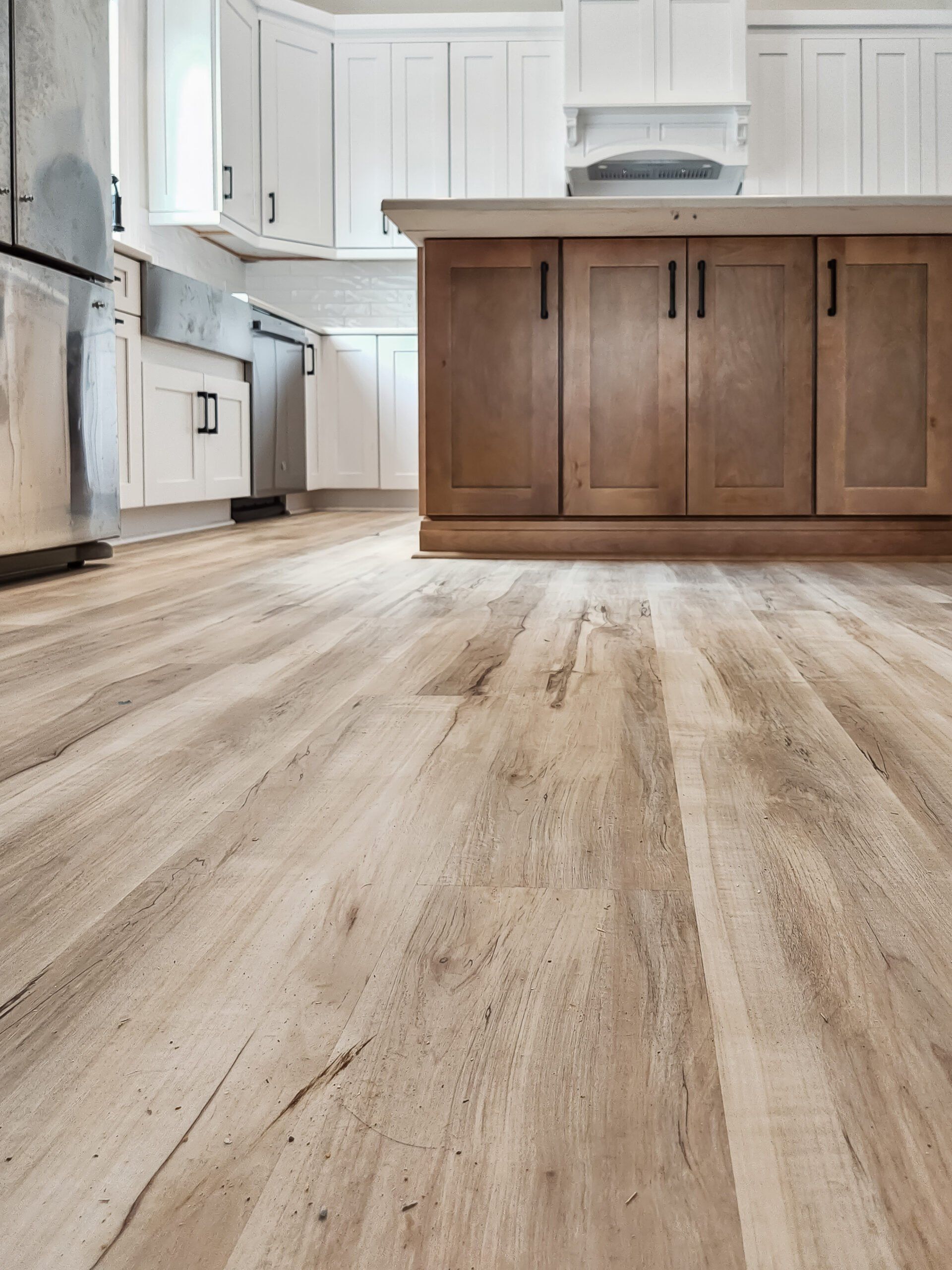 A kitchen with a wooden floor and white cabinets