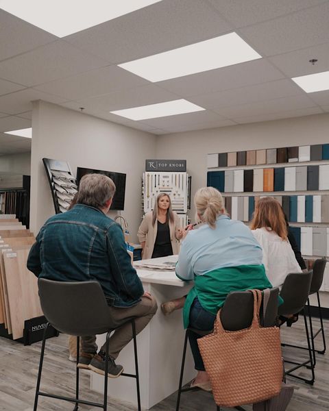 A group of people are sitting around a table in a room.