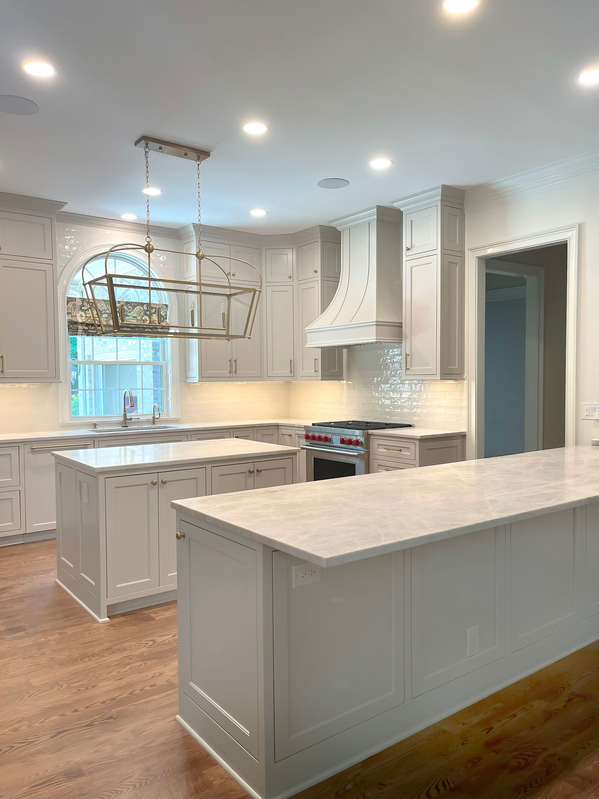 A kitchen with white cabinets and a large island in the middle.