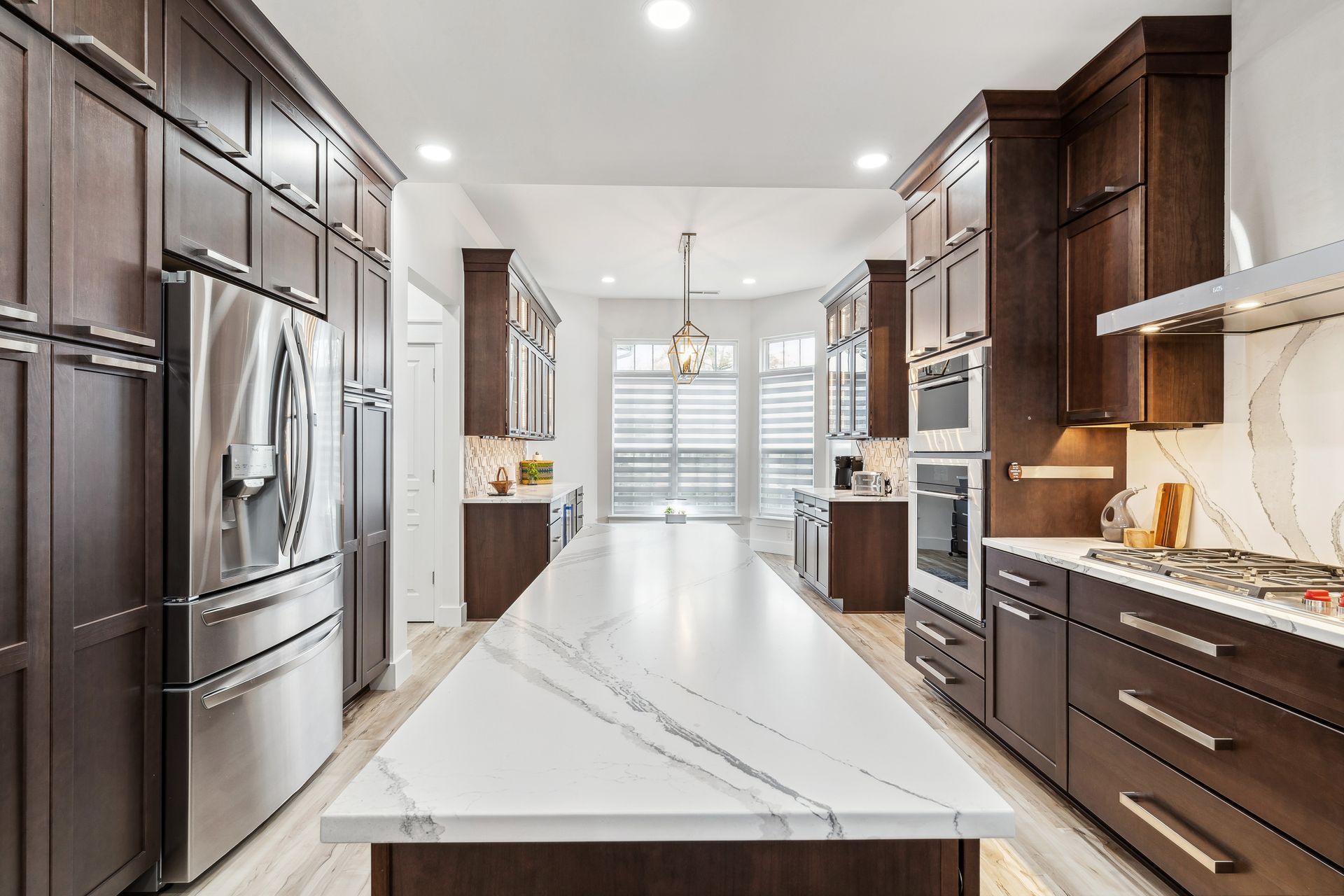 A kitchen with white cabinets and a large island in the middle.