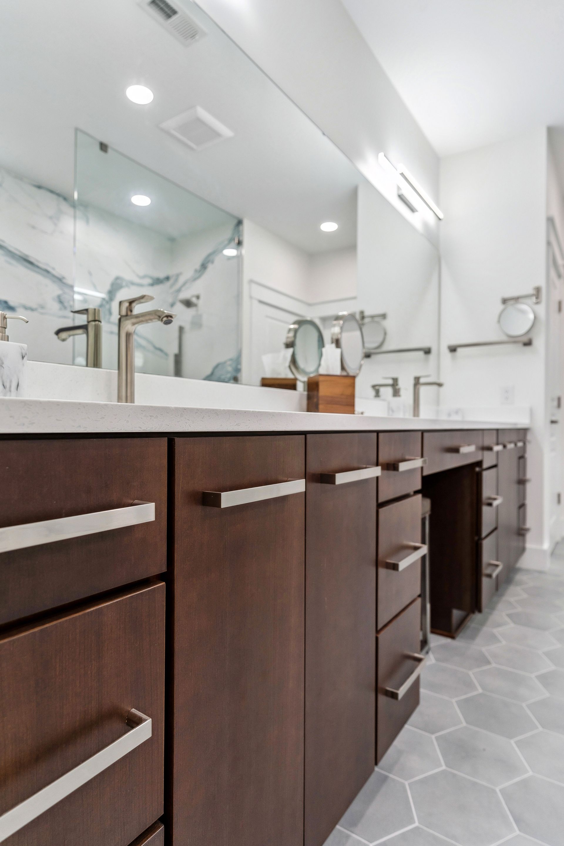 A bathroom with two sinks and a large mirror.