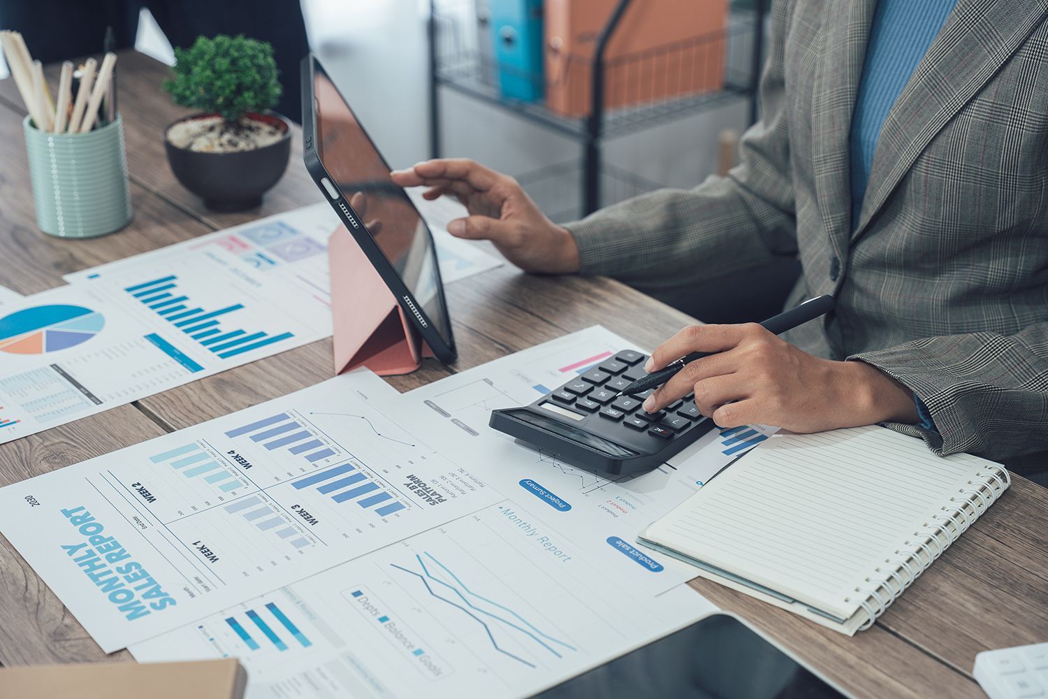 An accountant analyzing tax documents, charts, and a calculator on a clean desk. An accountant analyzing tax documents, charts, and a calculator on a clean desk.