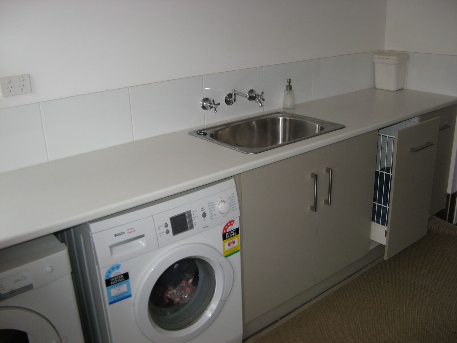 Laundry Room with A Sink, Countertop, Cabinets, and A Front-Loading Washer and Dryer — Simmonds Kitchens in Tamworth, NSW