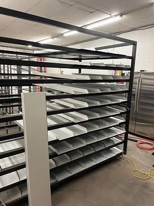 A warehouse filled with lots of shelves and a refrigerator.