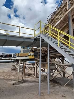 A bridge with stairs leading up to it and a yellow railing.