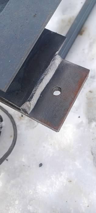 A piece of metal with a hole in it is sitting on the ground.