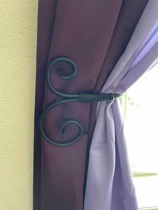 A close up of a curtain tie back on a window.