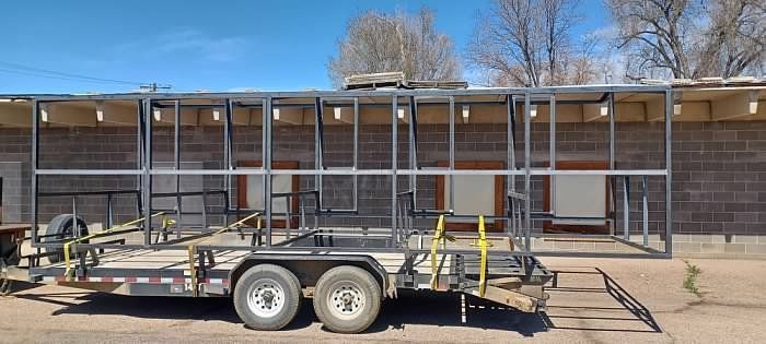 A trailer is parked in front of a brick building.
