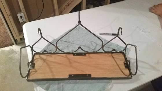 A wooden shelf is sitting on top of a white table.