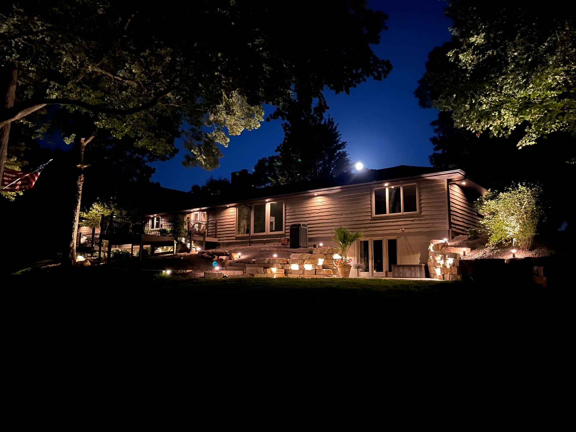 Woman adjusts smart lighting color on a tablet. Lights illuminate a dark ceiling, changing color.