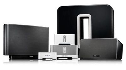 Collection of Sonos wireless speakers in various sizes and colors, including black and white models.