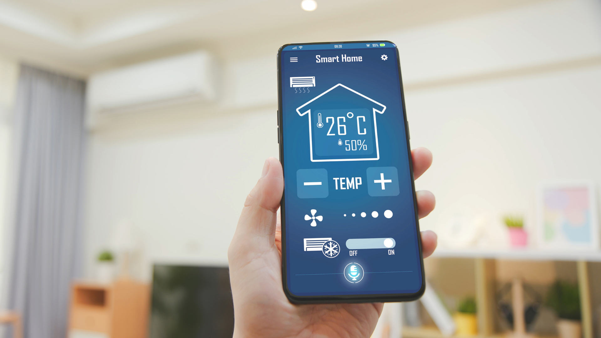 Hand holding smartphone displaying smart home controls, including temperature adjustment.
