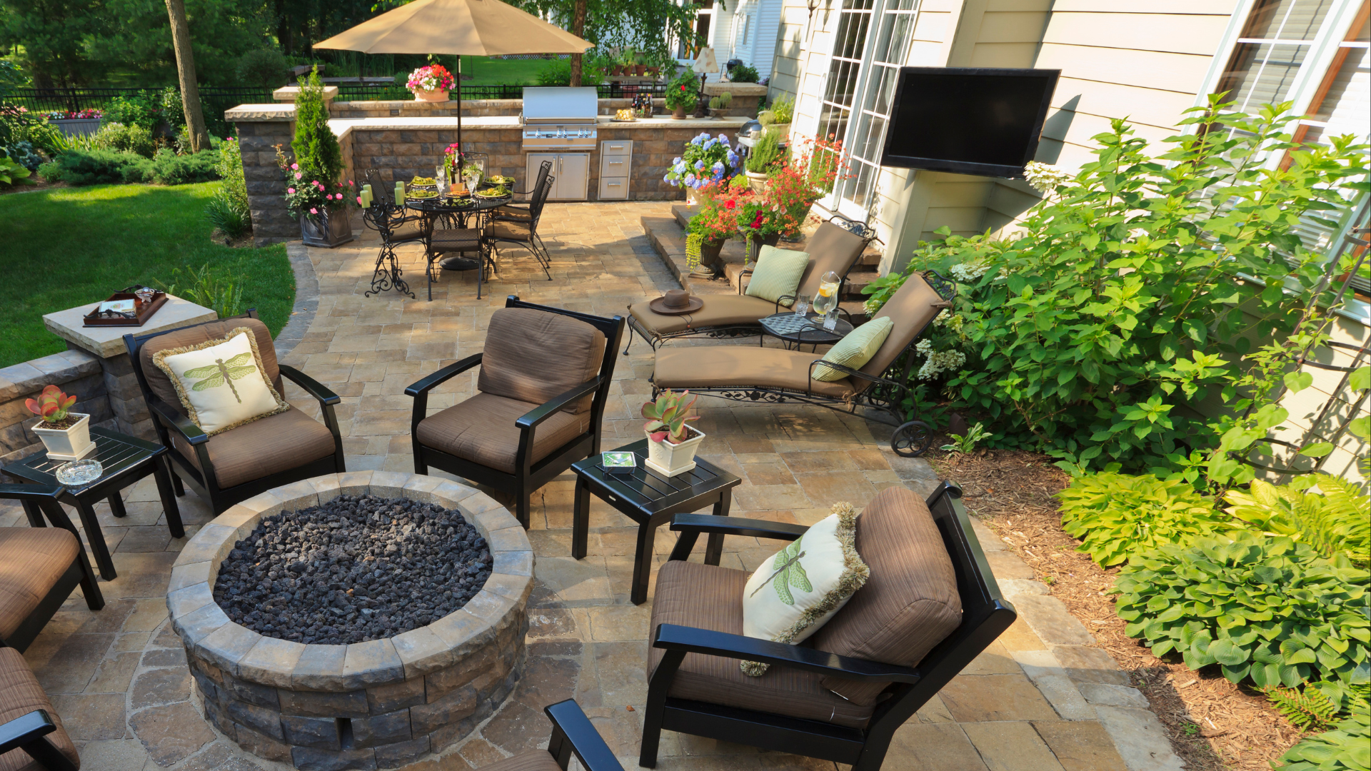 Outdoor patio with a fire pit, seating area, and an outdoor kitchen.