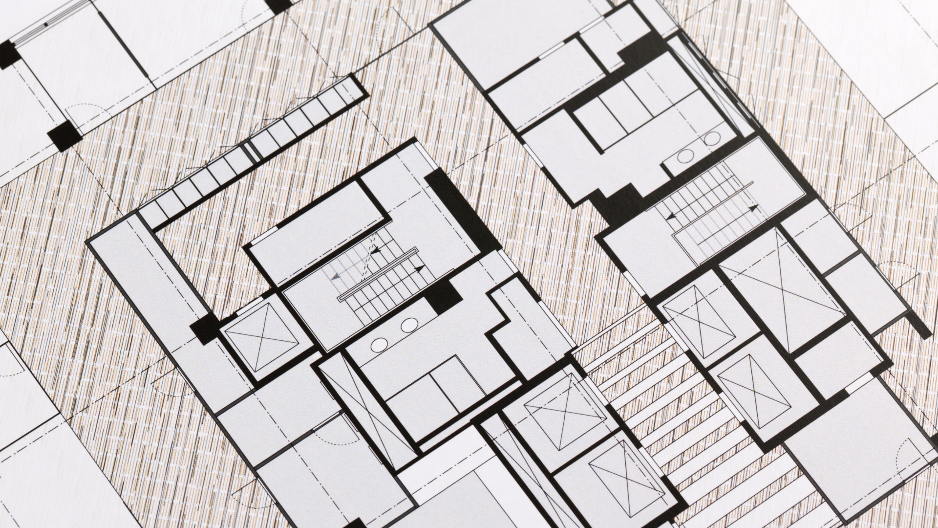 Architectural floor plan, black lines on textured tan background, detailing rooms and stairs of a building.