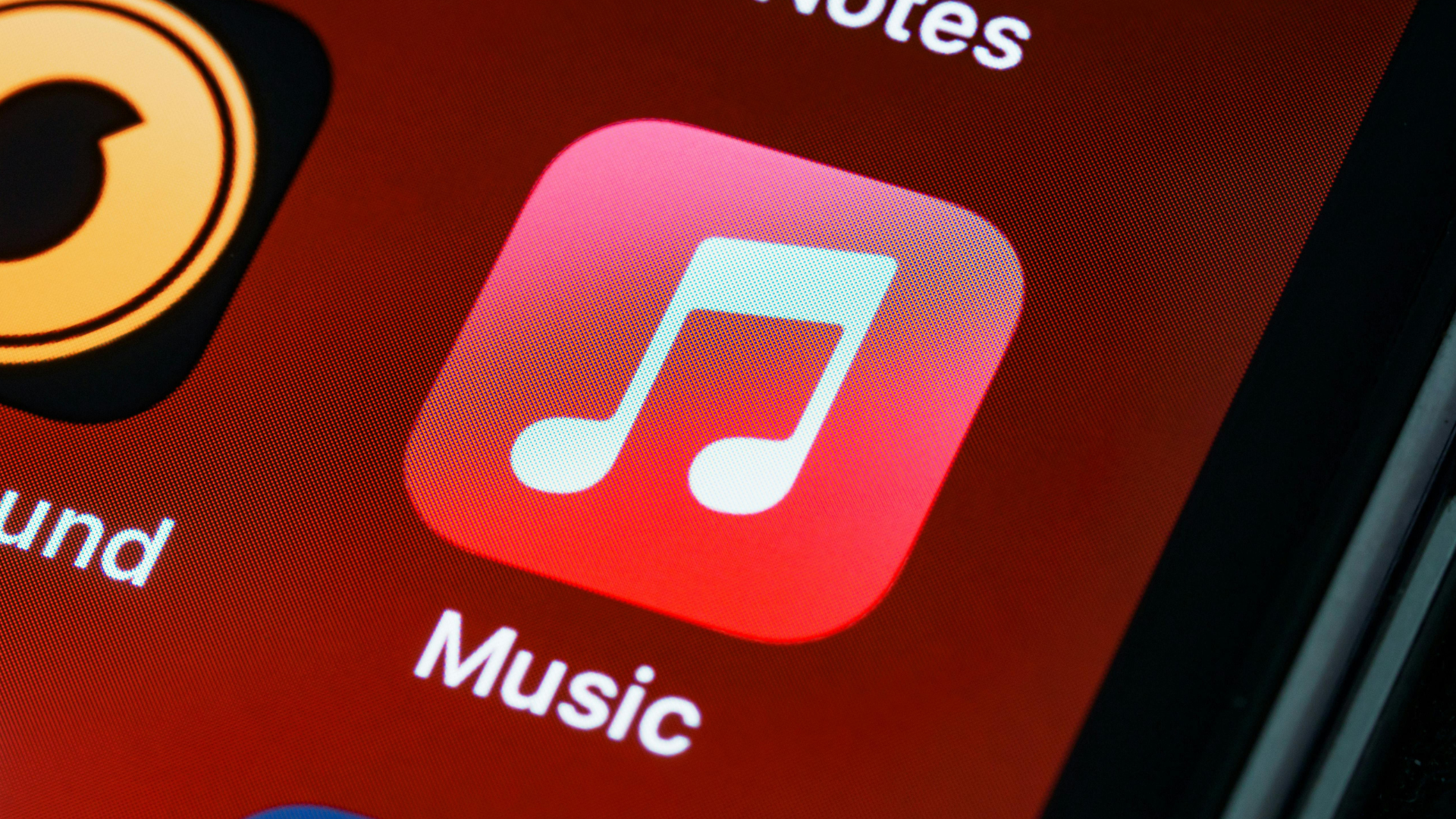 Apple Music app icon, white musical note on red square background.