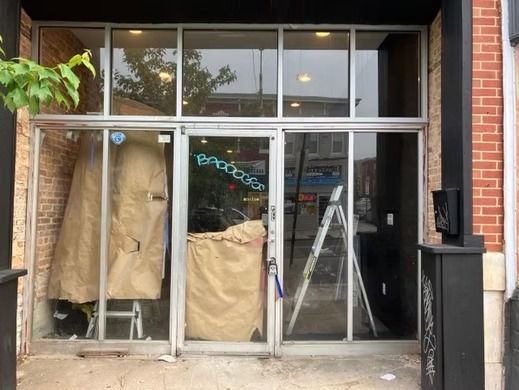 Storefront with glass doors, papered interior, construction, and ladder.