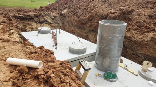 A septic tank is being built in a hole in the ground.