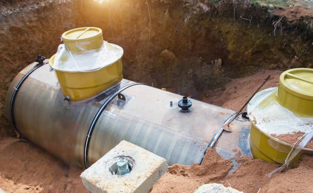 A large metal tank is sitting in a hole in the ground.