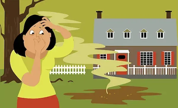 Concrete drainage project with pipe, framed by wood planks and rocks, in a grassy yard.