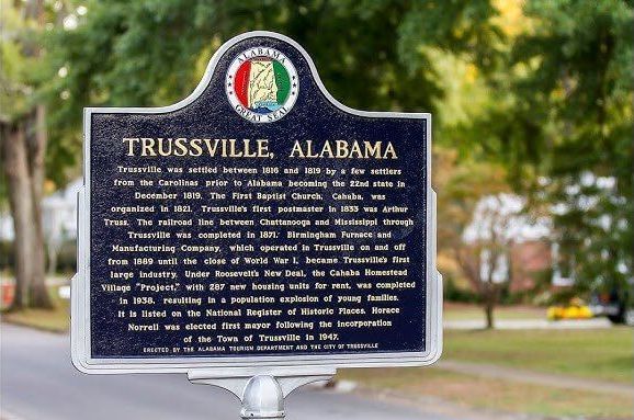A historical marker for trussville alabama is sitting on the side of the road.