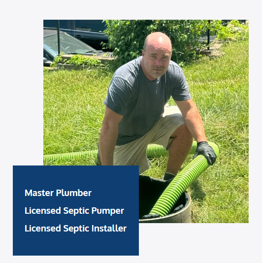 A man is kneeling down in the grass holding a green hose