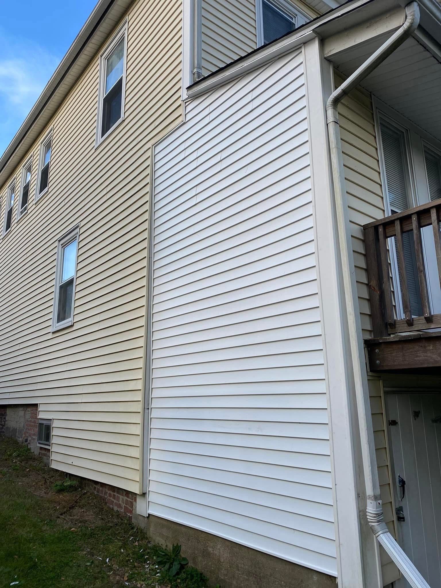 Woman in straw hat smiles, holding wine glass near a lake.
