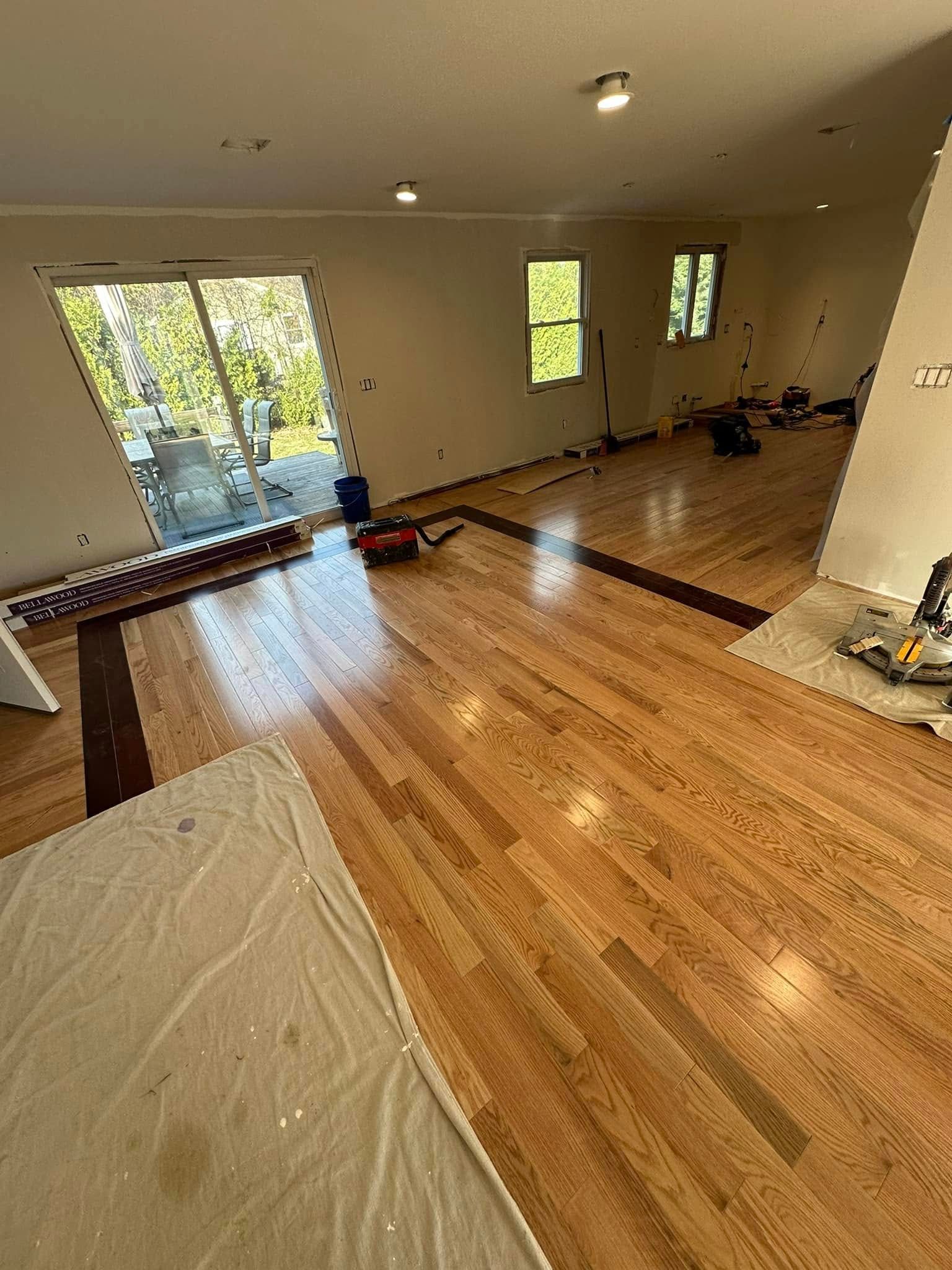 Woman in straw hat smiles, holding wine glass near a lake.