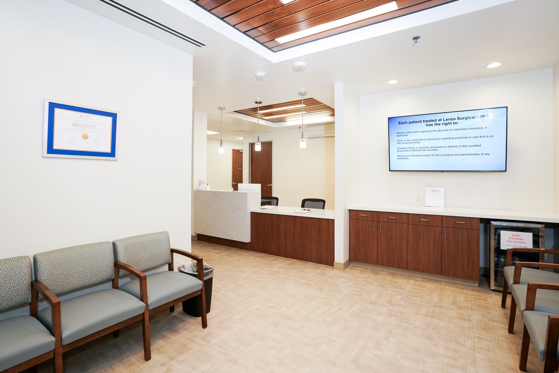 Surgeons in blue scrubs operate on a patient in an operating room.