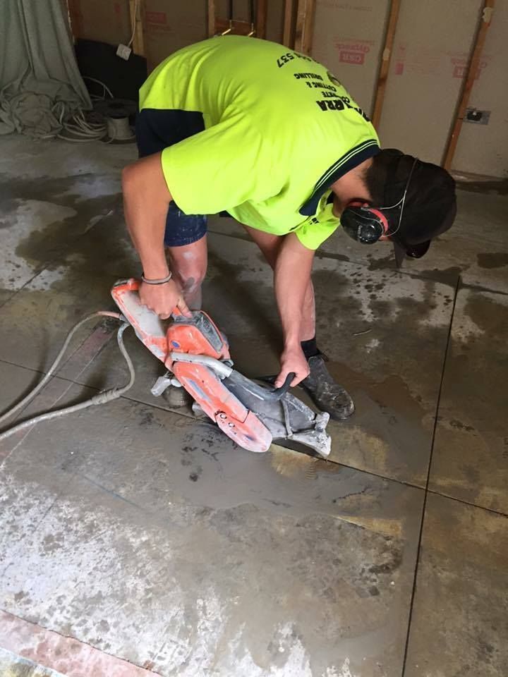 Construction Worker Cutting Concrete Floor With Power Saw — Dondarra Concrete Cutting & Drilling in Parkhurst, QLD