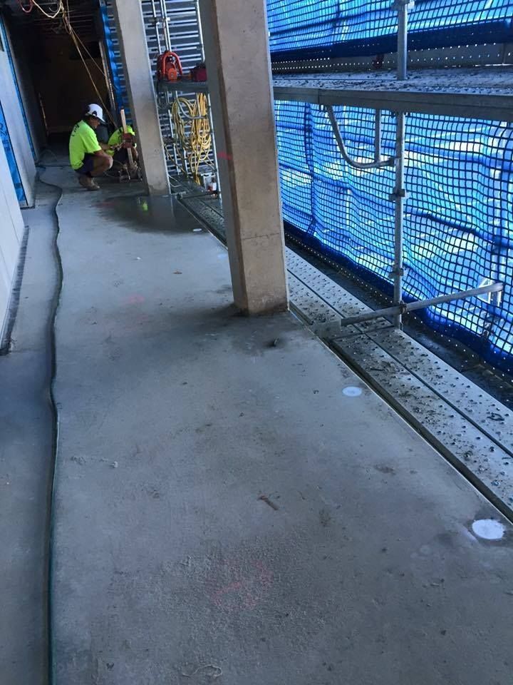 Construction Worker Grinding Concrete Floor — Dondarra Concrete Cutting & Drilling in Parkhurst, QLD