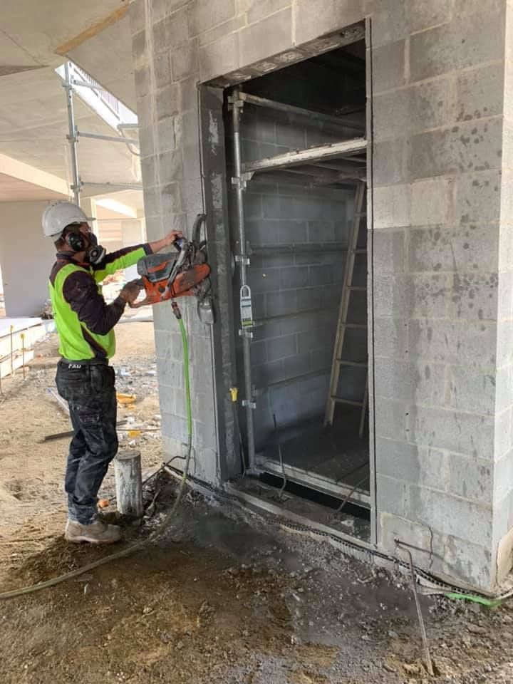 Construction Worker Cutting Doorway in Concrete Block Wall — Dondarra Concrete Cutting & Drilling in Parkhurst, QLD