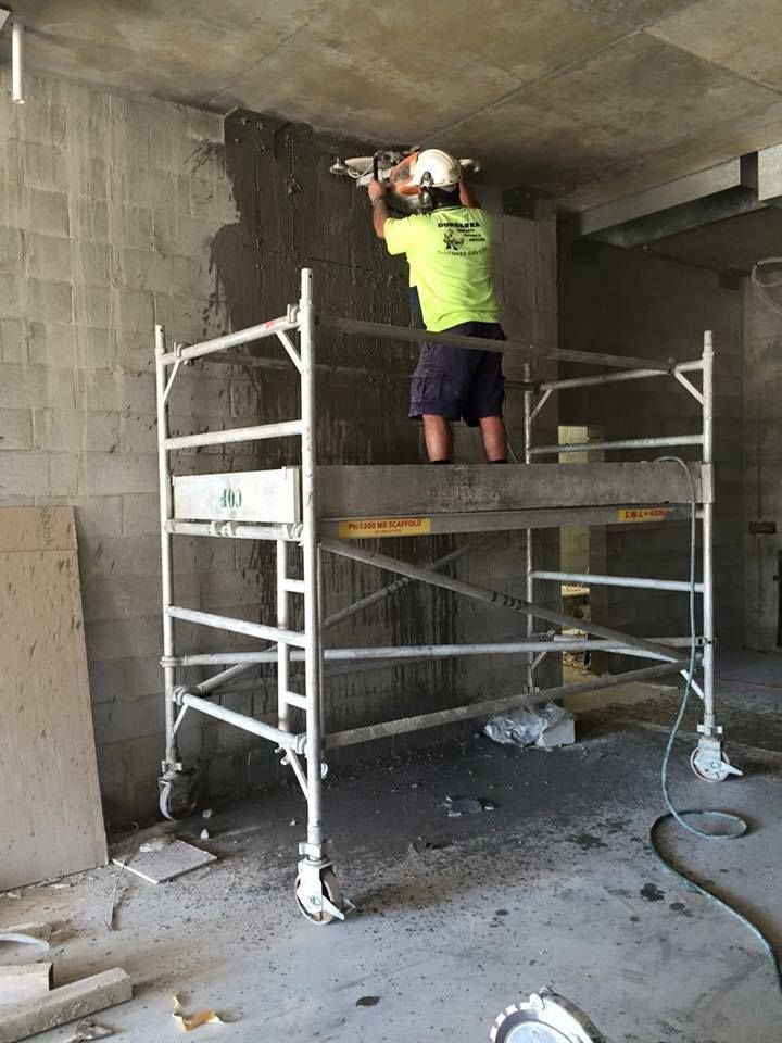 Construction Worker on Scaffold Applying Plaster to Wall — Dondarra Concrete Cutting & Drilling in Parkhurst, QLD