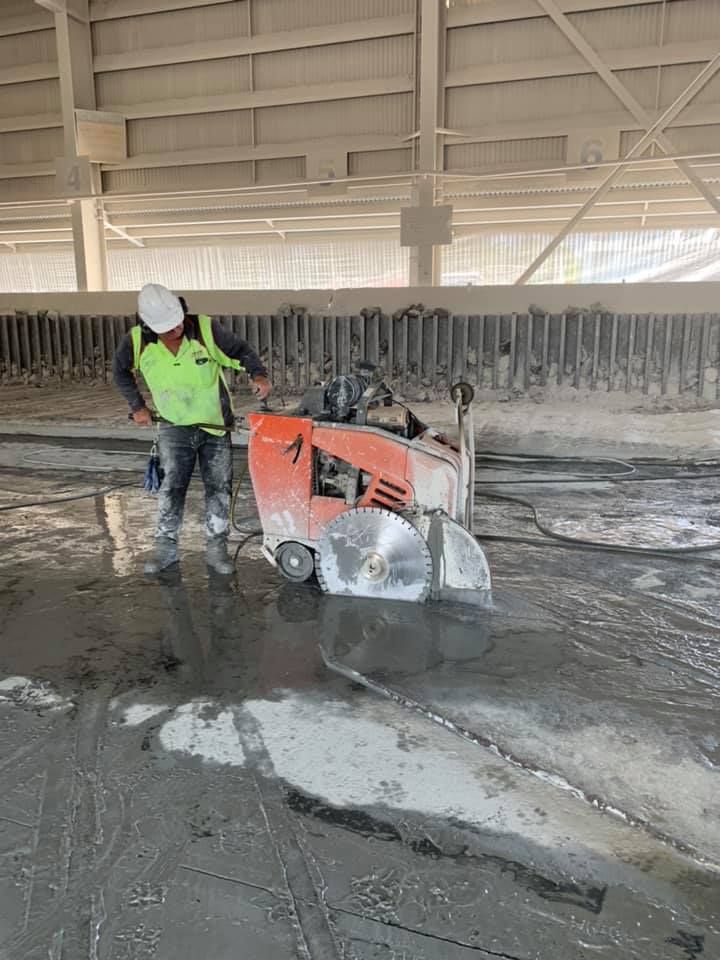 Worker Using a Concrete Saw to Cut Through a Concrete Floor — Dondarra Concrete Cutting & Drilling in Parkhurst, QLD