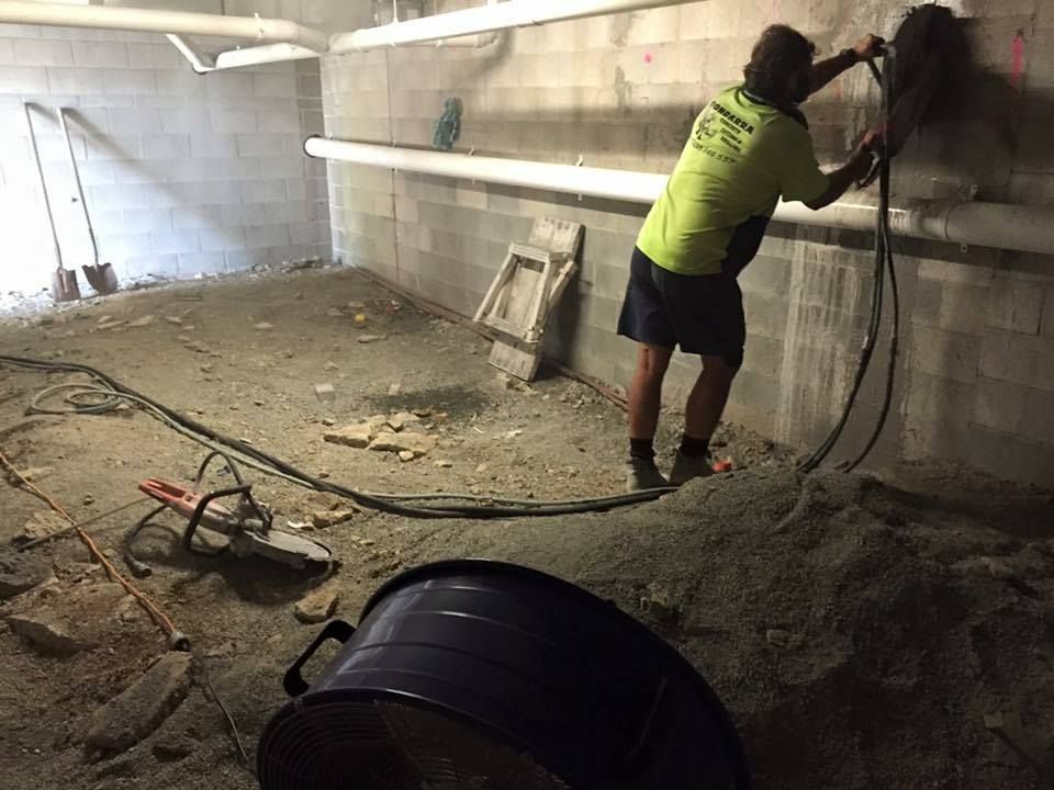 Man Using a Drill in a Construction Zone — Dondarra Concrete Cutting & Drilling in Parkhurst, QLD