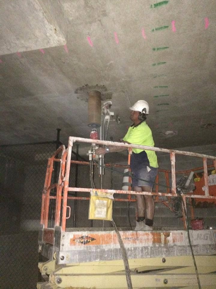 Construction Worker in a Lift Using a Drill on a Concrete Ceiling — Dondarra Concrete Cutting & Drilling in Parkhurst, QLD