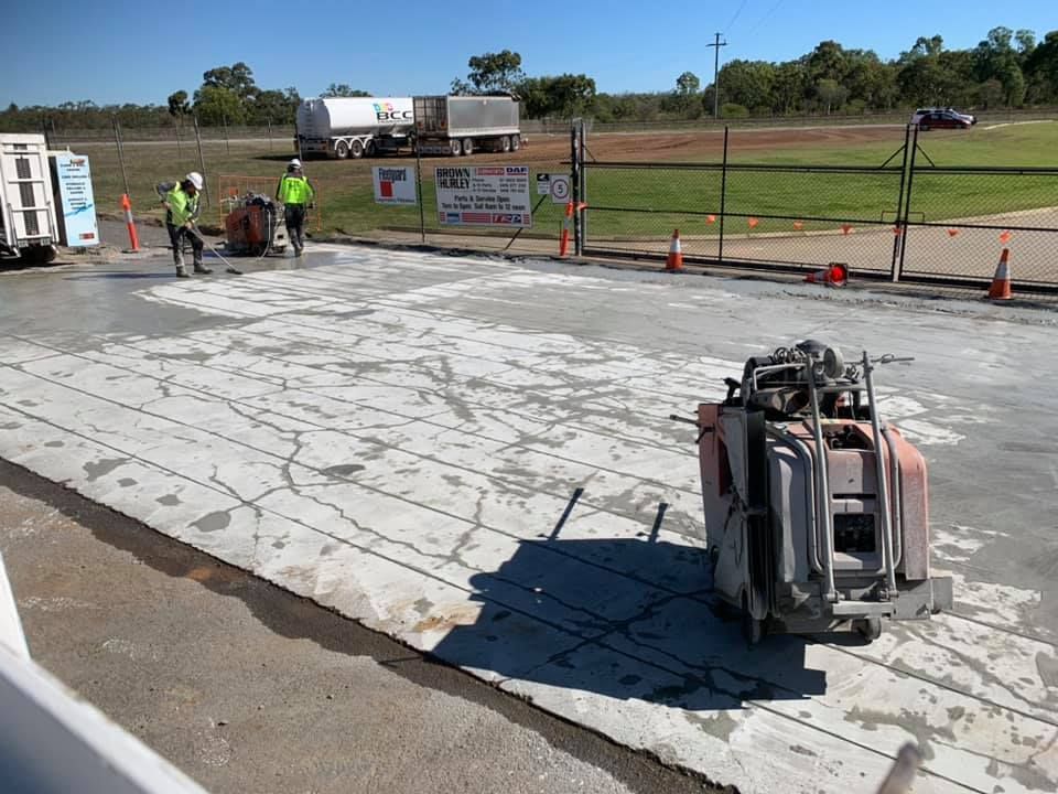 Workers Cutting Concrete Pavement With Industrial Saws — Dondarra Concrete Cutting & Drilling in Parkhurst, QLD