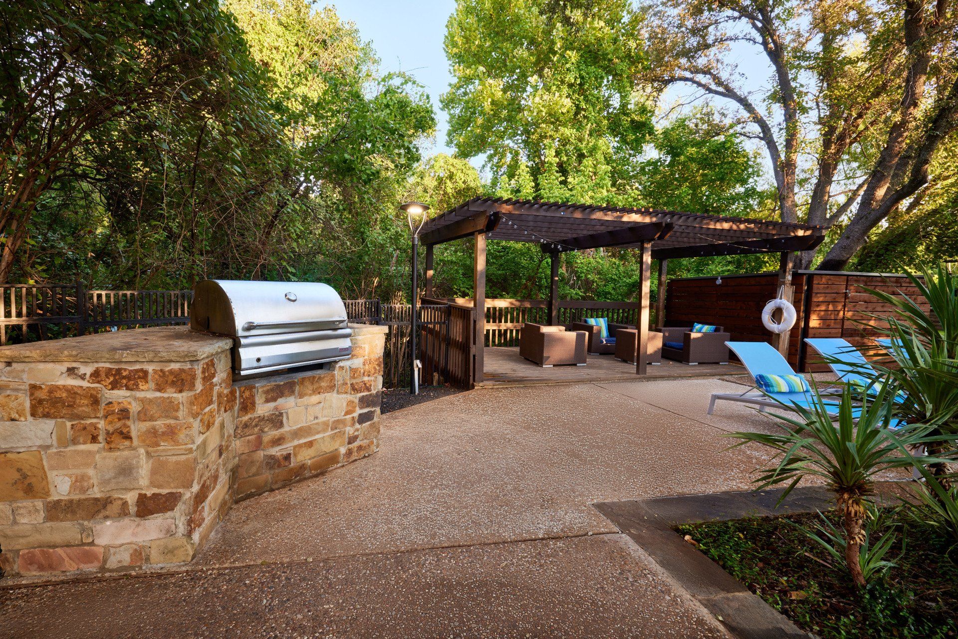 A grill and a gazebo poolside at Summerwood Cove Apartments.