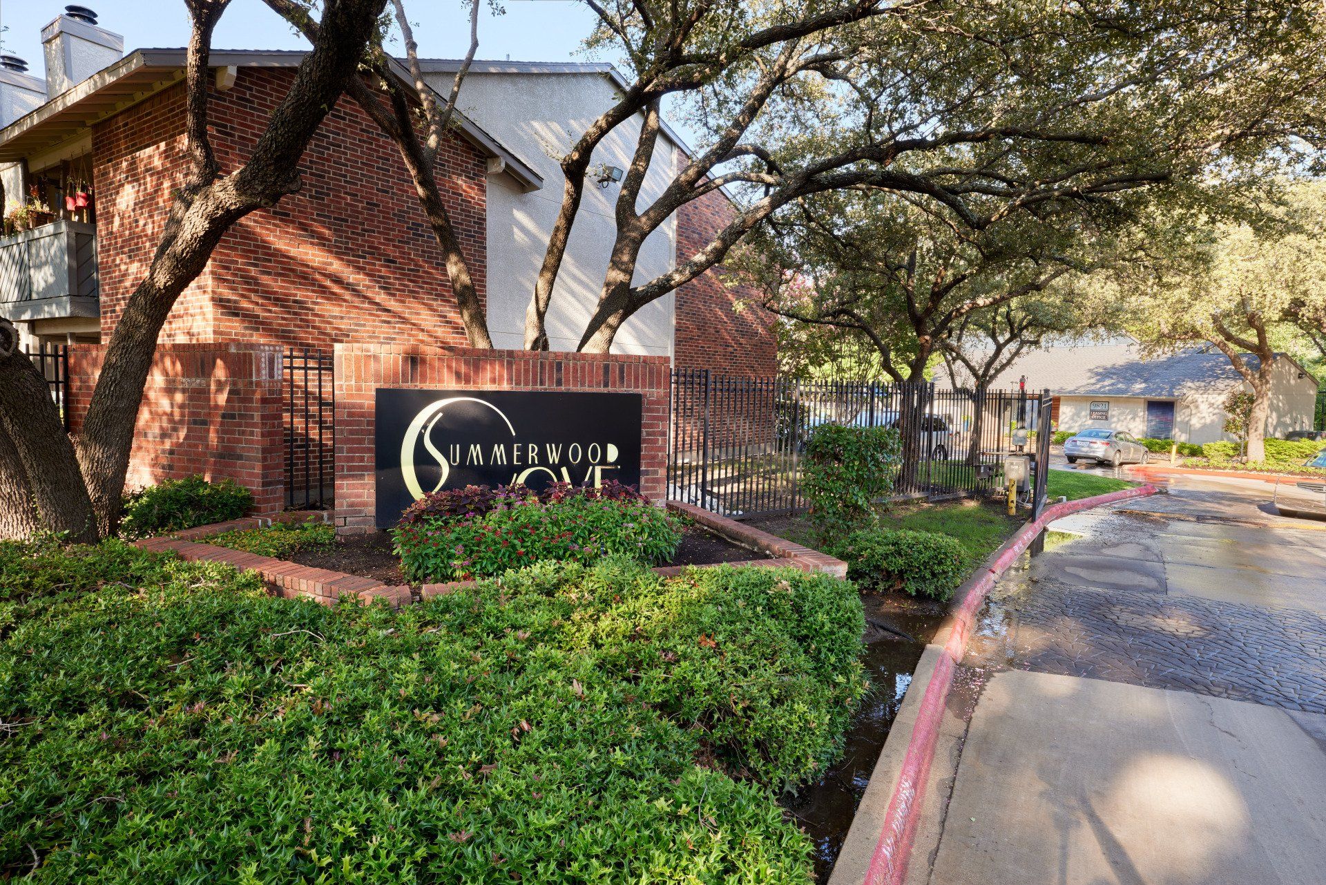 A brick building with a sign in front of it at Summerwood Cove Apartments.