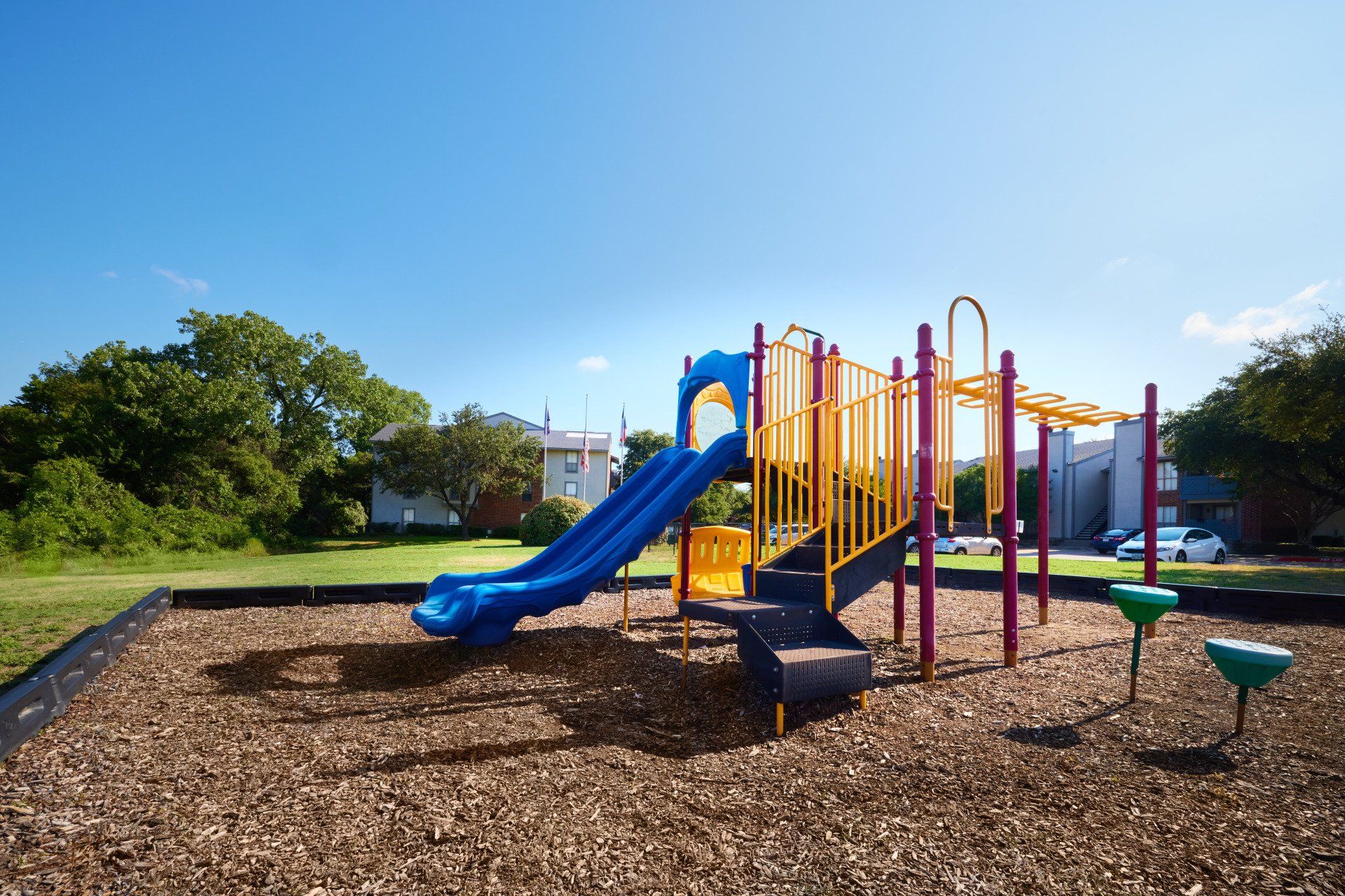 A playground with a slide and a water fountain at Summerwood Cove Apartments.