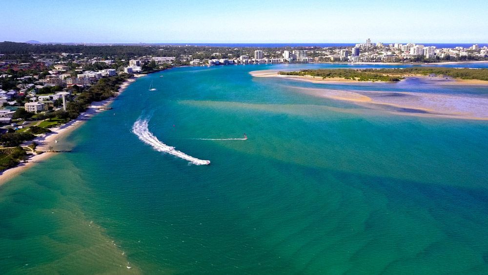An Aerial View Of A Body Of Water With A Boat Going Through It — Climatech In Caloundra, QLD