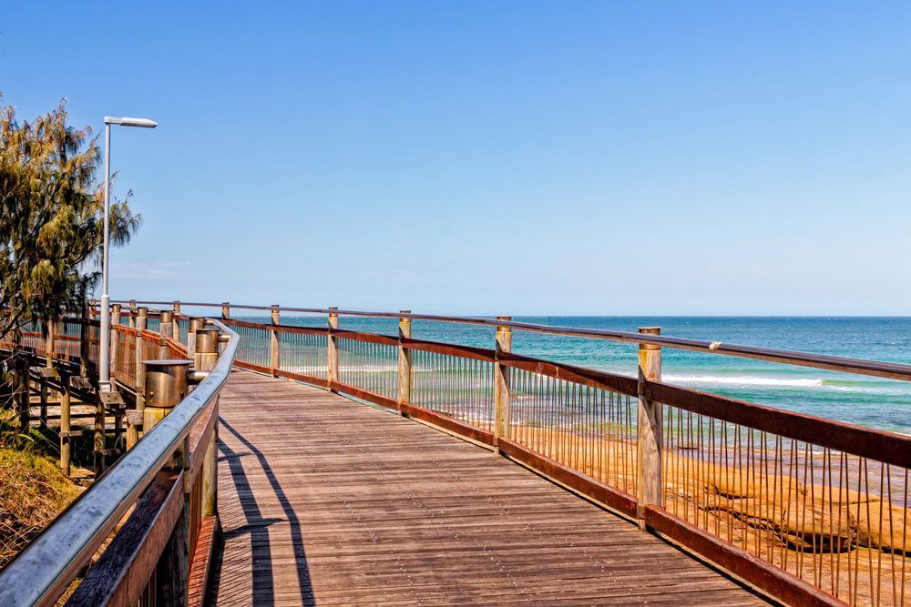 A Wooden Walkway Leading To The Ocean On A Sunny Day — Climatech In Caloundra, QLD