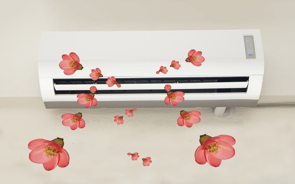 A White Air Conditioner With Pink Flowers On It — Climatech In Marcoola, QLD