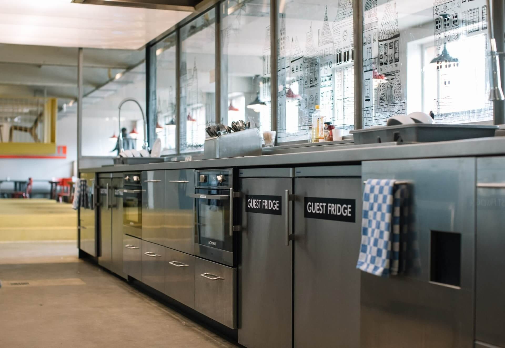 A Kitchen With Stainless Steel Cabinets And Appliances And A Towel Hanging On The Door — Climatech In Marcoola, QLD