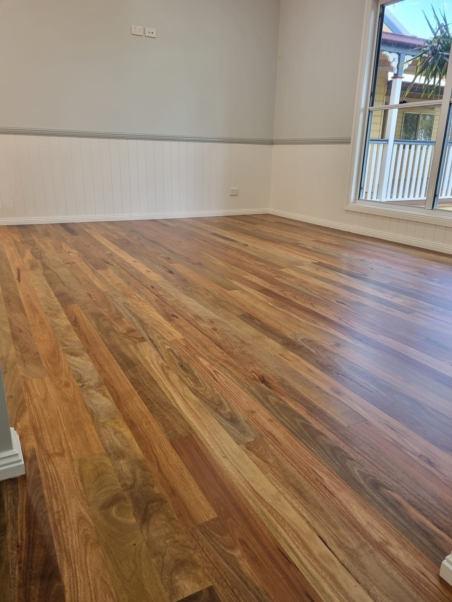 Wooden Floor in an Empty Room With White Walls — The Good Wood Polished Timber Floors in Oakey, QLD