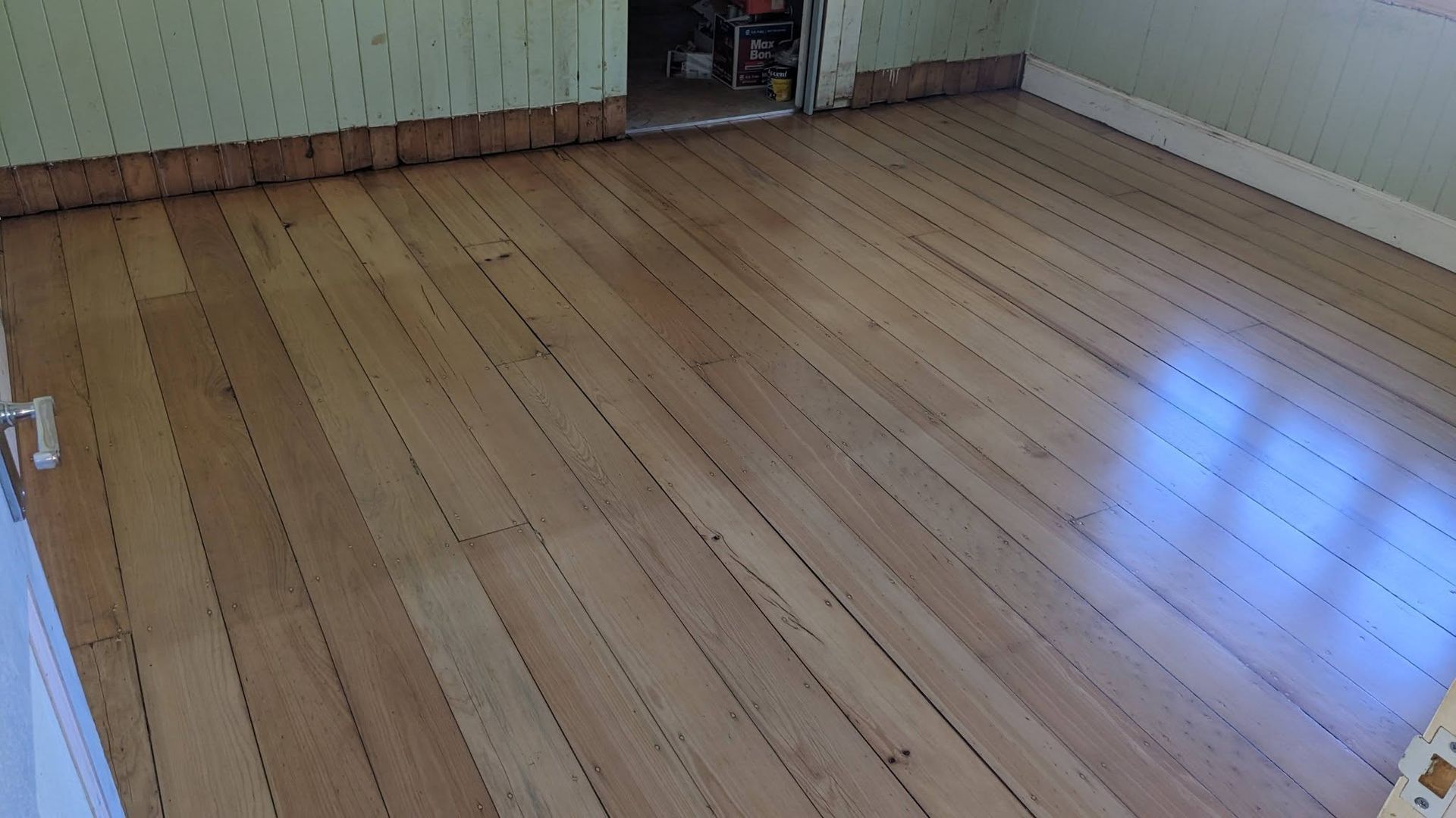 Wooden floor in room with light green walls and doorway. — The Good Wood Polished Timber Floors in Gatton, QLD
