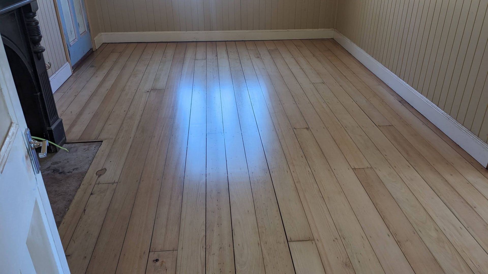 Light wood floor in a room with white trim and patterned wallpaper. Sunlight reflects on the surface. — The Good Wood Polished Timber Floors in Westbrook, QLD