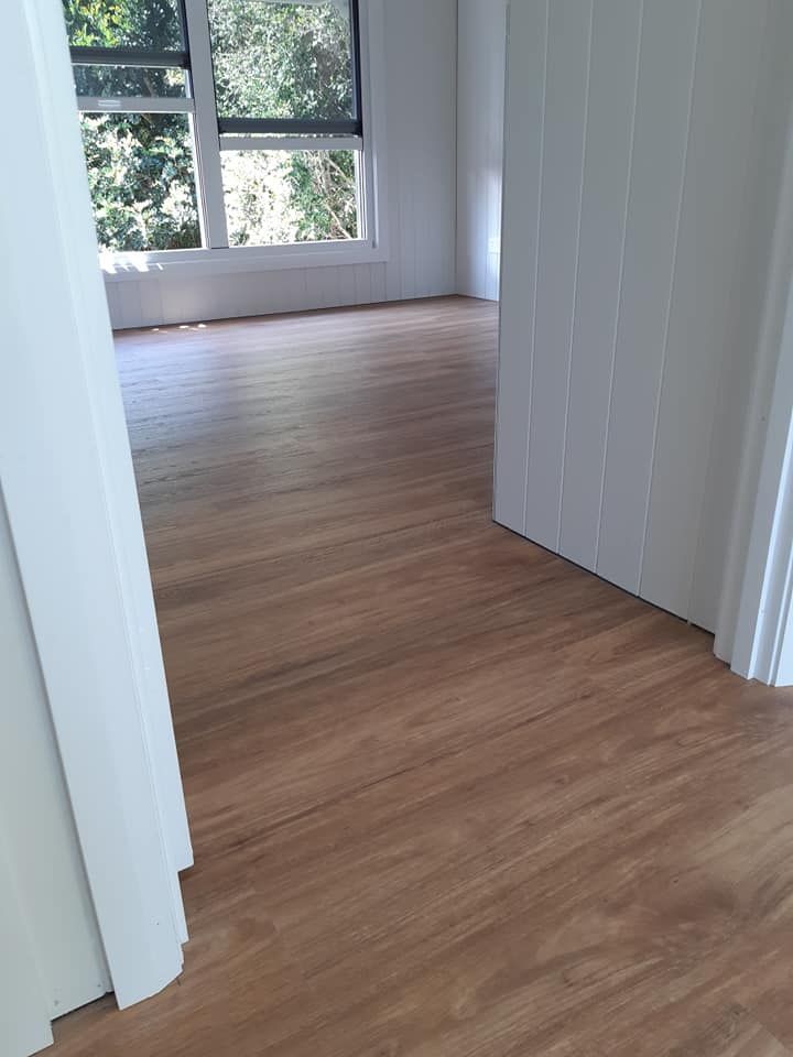 Wooden floor in a bright room, viewed from a doorway. Natural light through the window. — The Good Wood Polished Timber Floors in Oakey, QLD