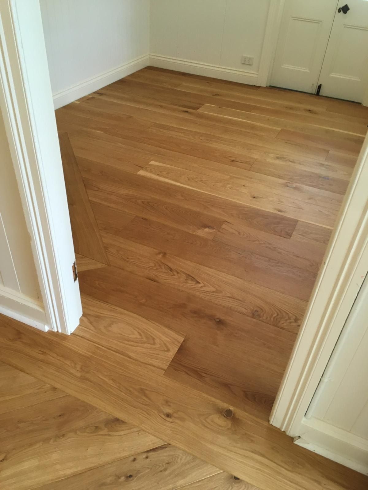 Wooden flooring in a room with white door frames. The floor transitions direction. — The Good Wood Polished Timber Floors in Pittsworth, QLD