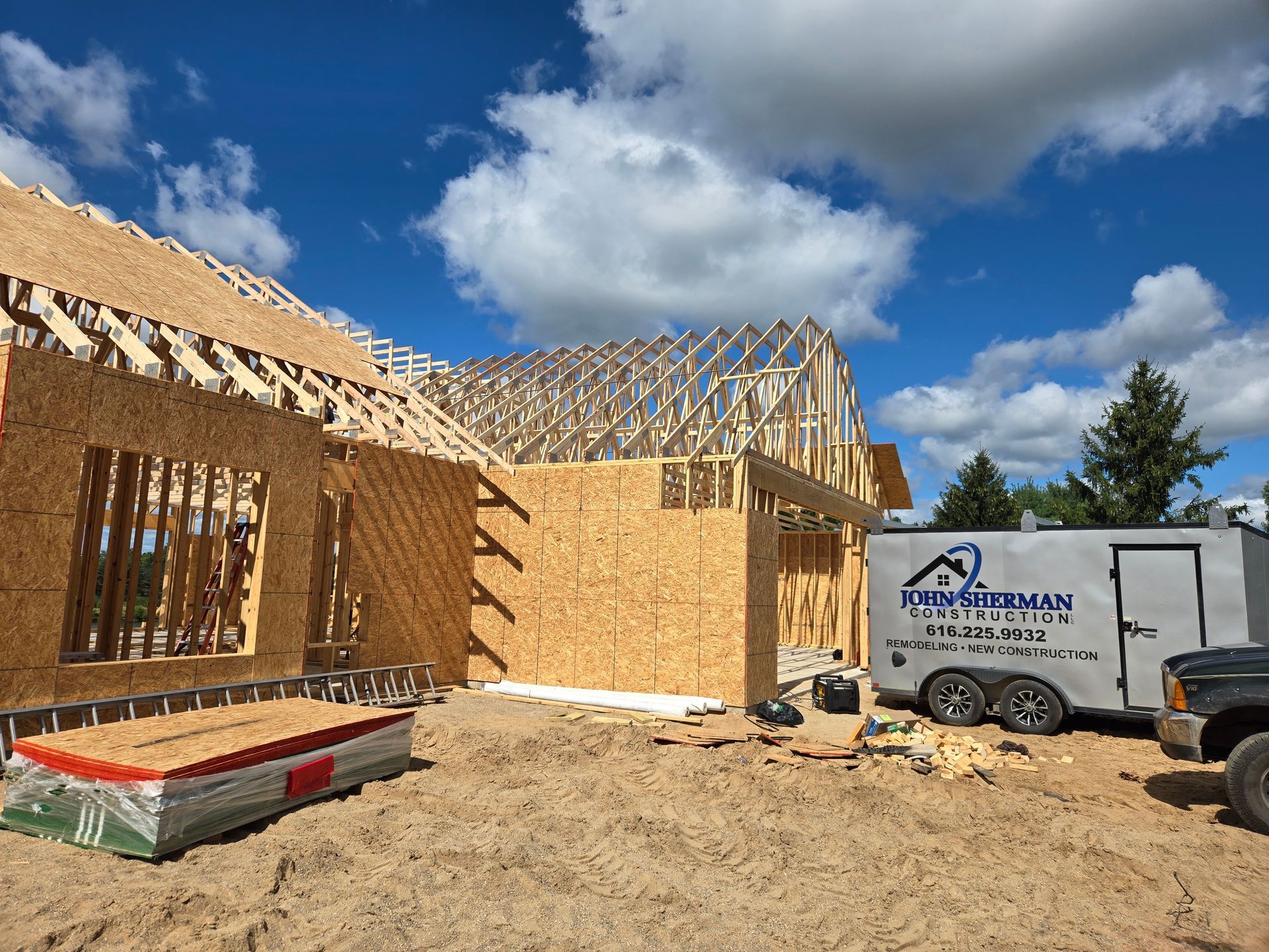 A house is being built in a field with the sun shining through the clouds.