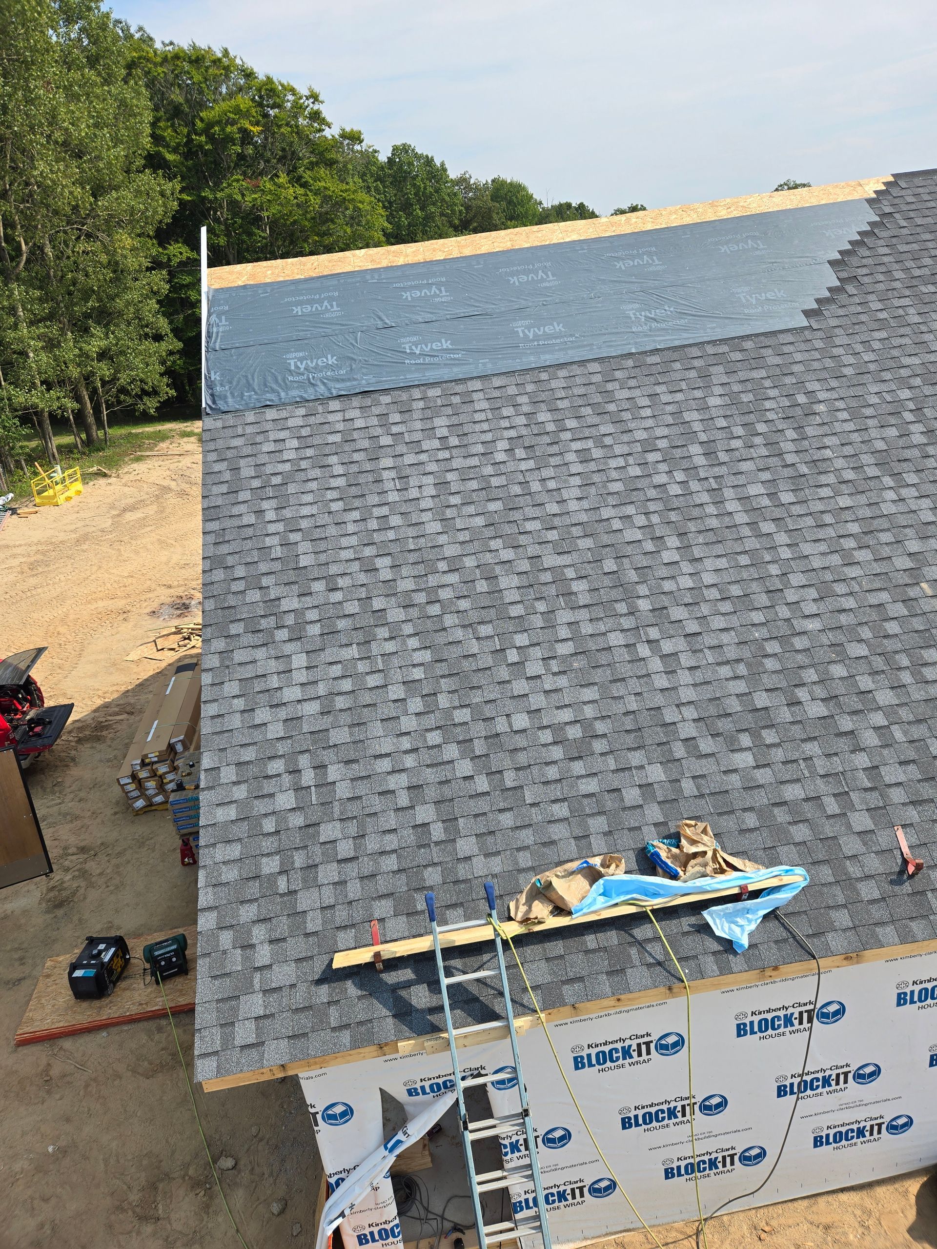 Two construction workers are working on a roof.